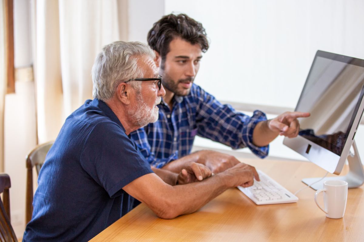 Senior man and his son figuring on computer