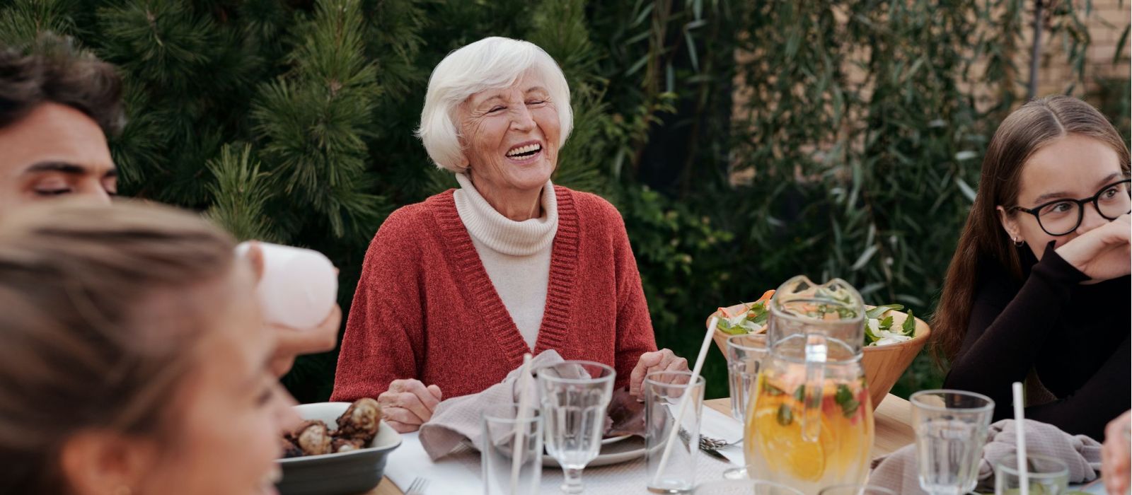 Senior women with family at the dinner table outdoors