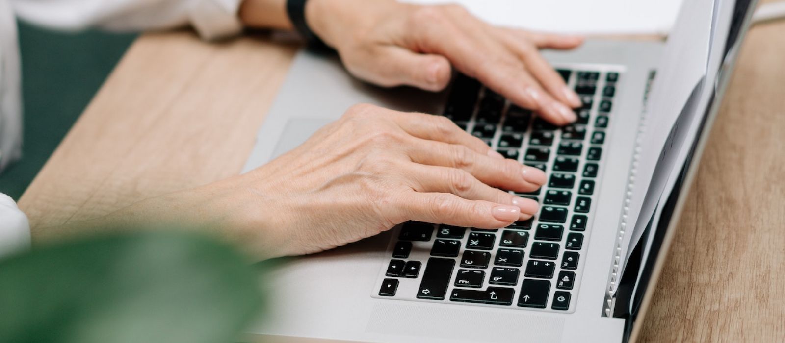 Woman typing on a computer at a desk.