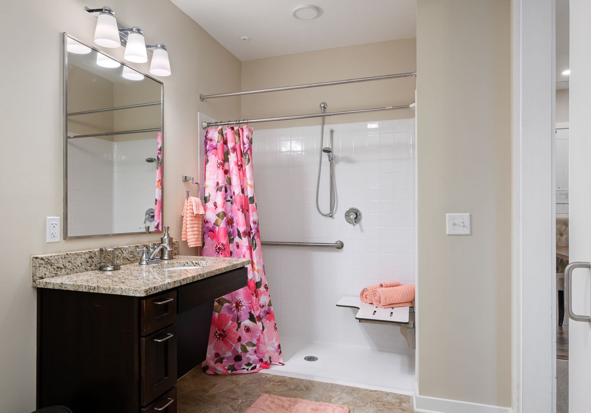 The Claiborne at Shoe Creek senior living community bathroom showing accessibility features including handrails, lower sink height, and zero-entry shower