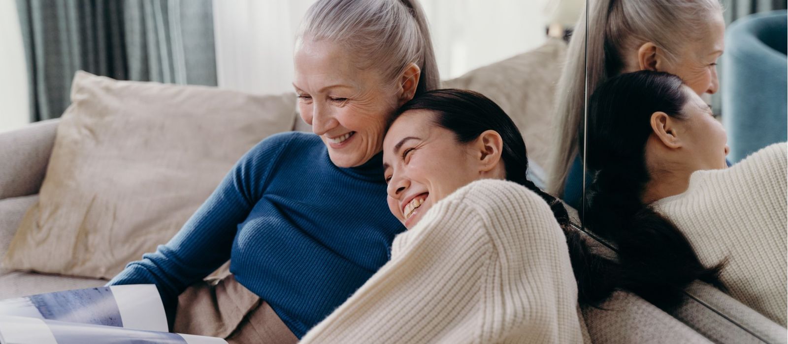 Mother daughter laughing together on a couch