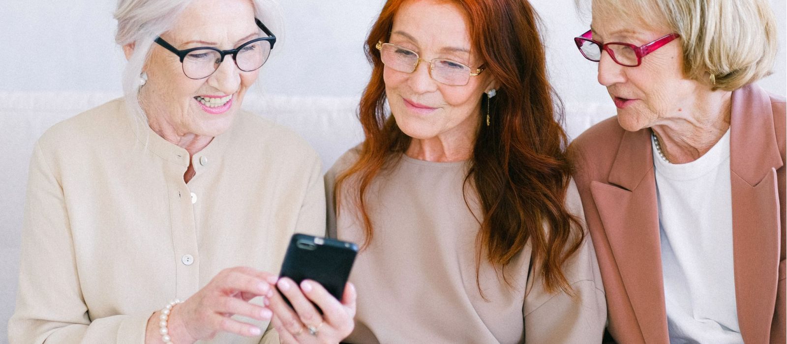 Senior women looking at a smartphone together.