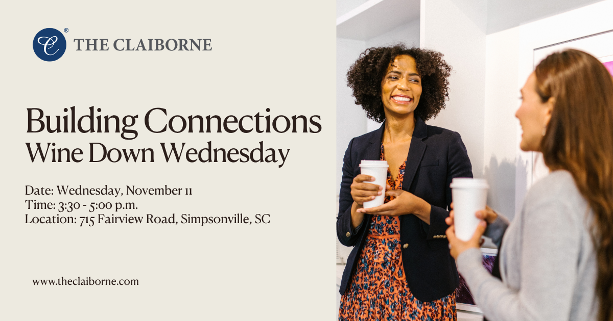 Two women smile and talk while holding coffee cups at a networking event called “Wine Down Wednesday” hosted by The Claiborne.