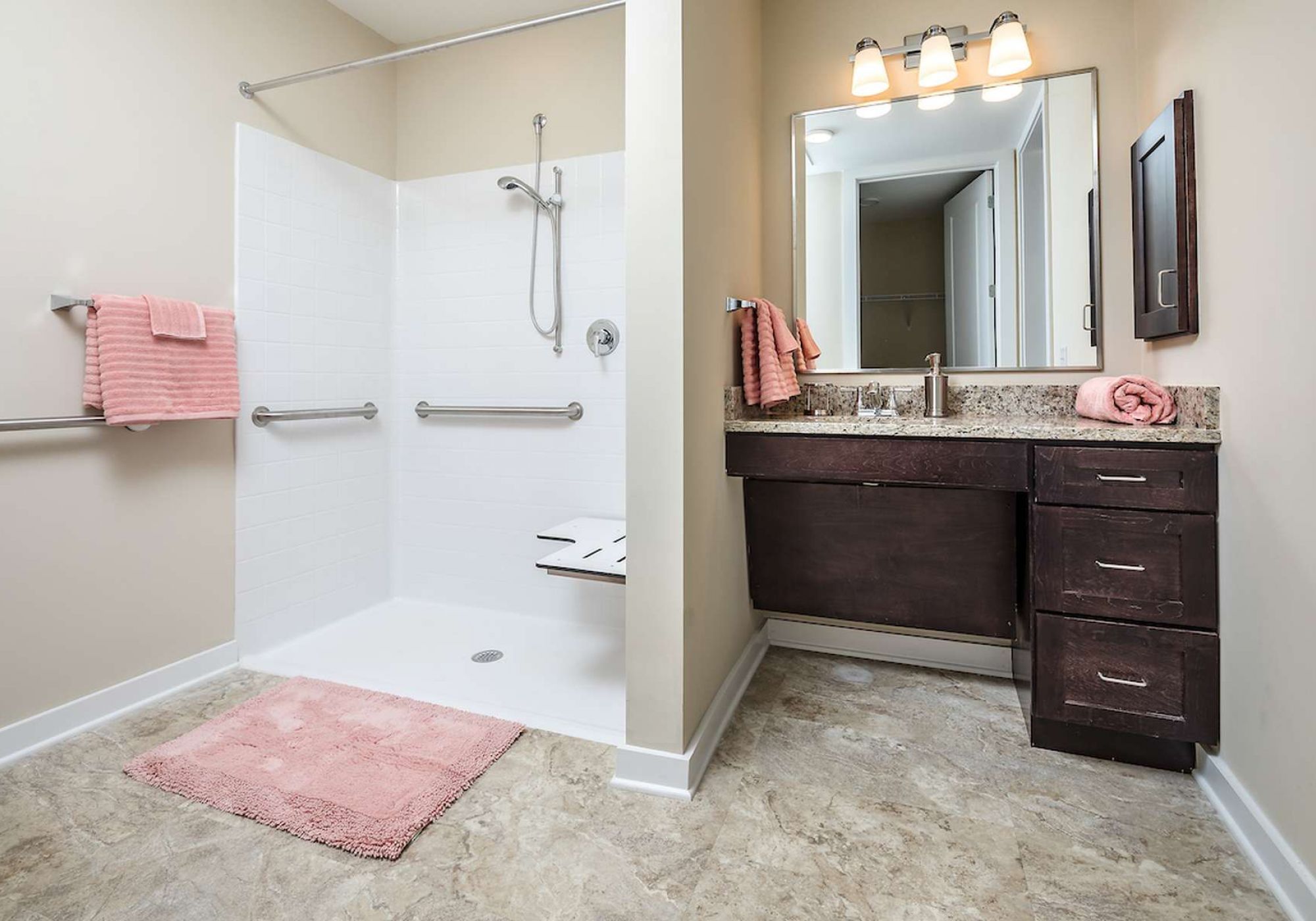 The Claiborne at West Lake senior living community bathroom showing accessibility features including handrails, lower sink height, and zero-entry shower