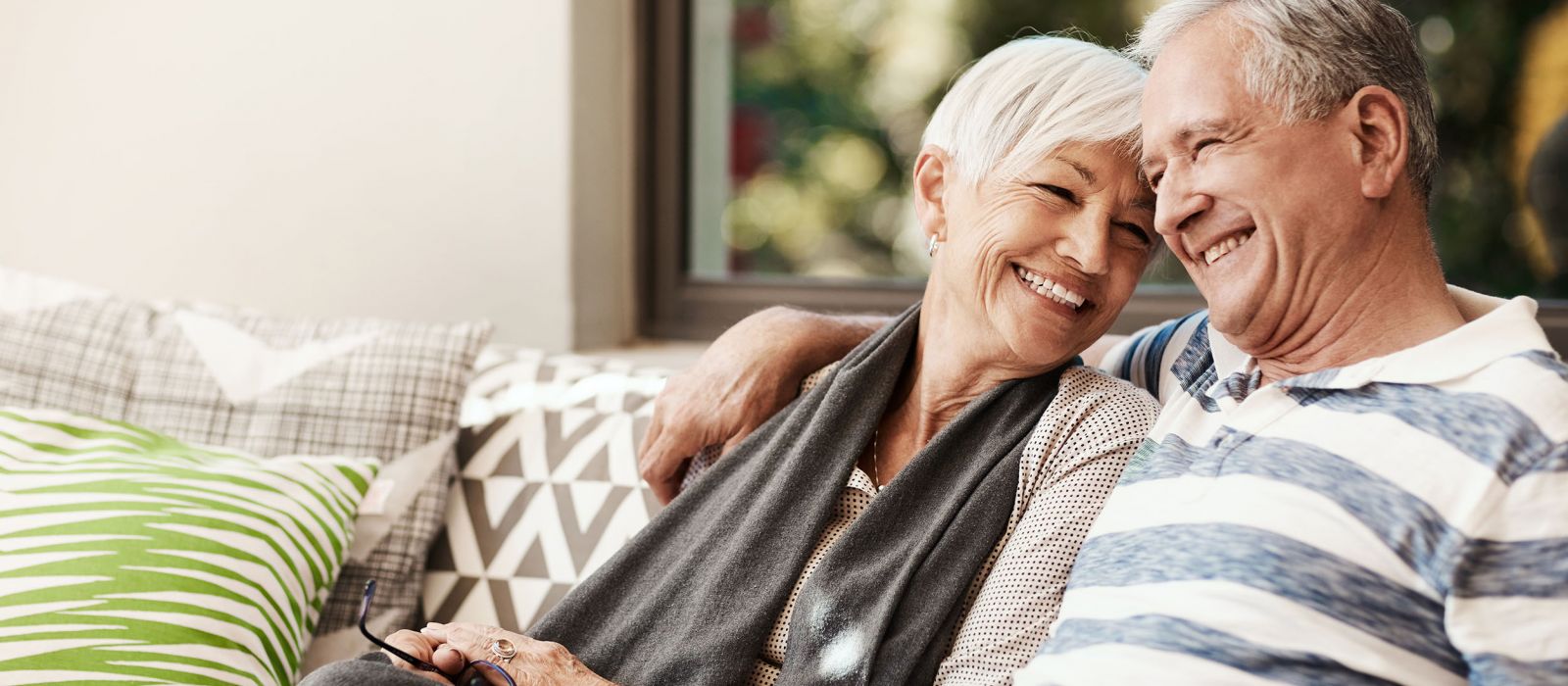 Senior couple sitting on porch and hugging