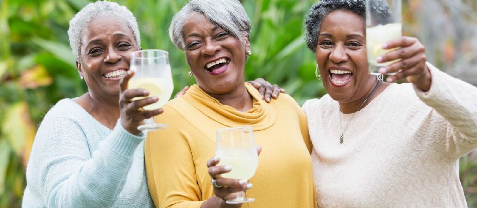 Senior women happily celebrating with drinks