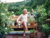 The Claiborne at West Lakewoman drinking coffee sitting on bench with dog