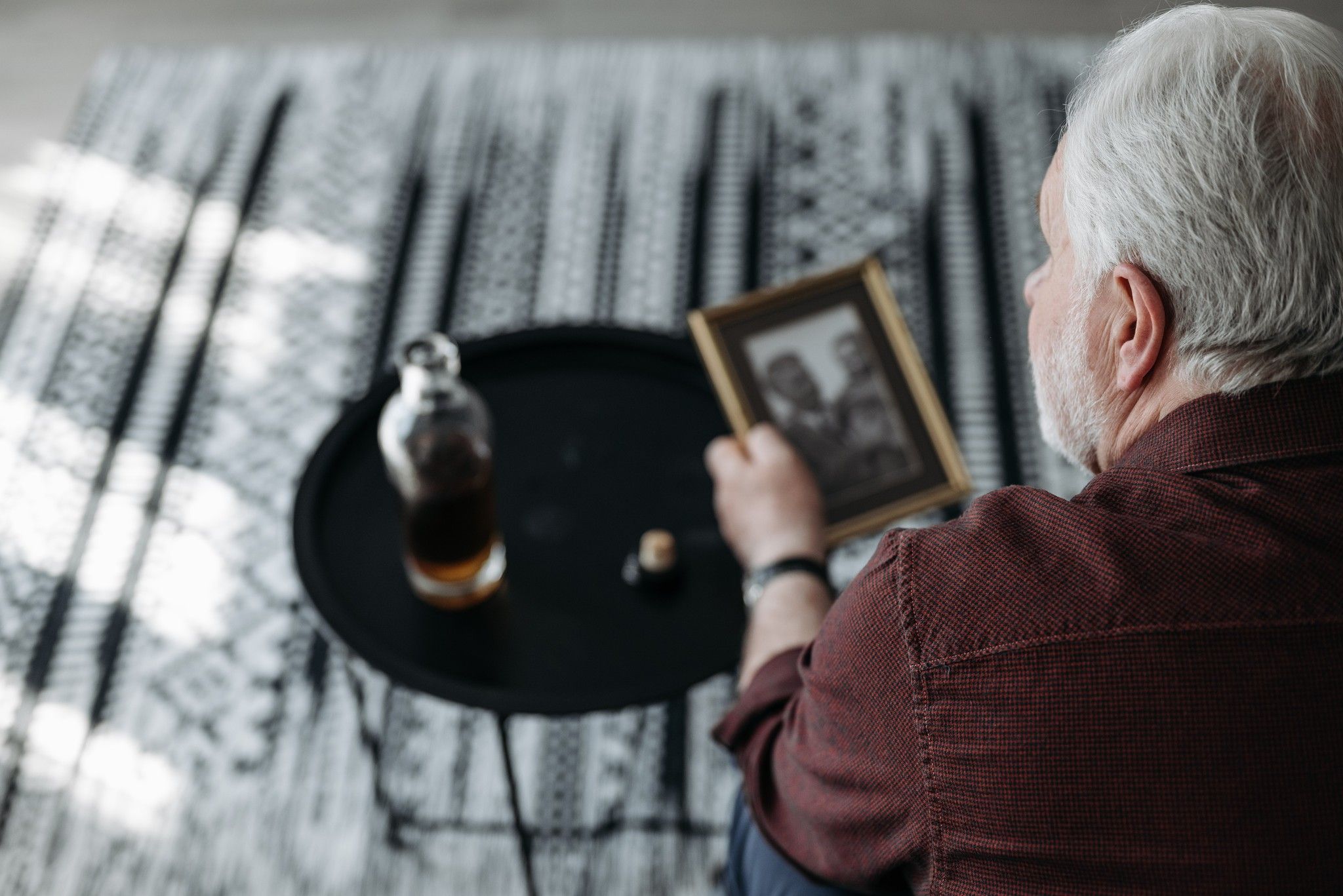 Man looking at a picture frame in a living room