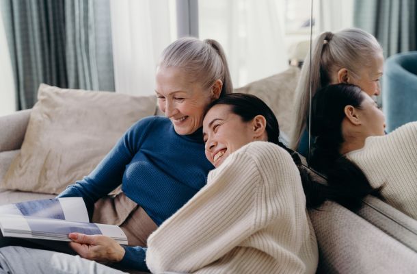 Mother daughter laughing together on a couch