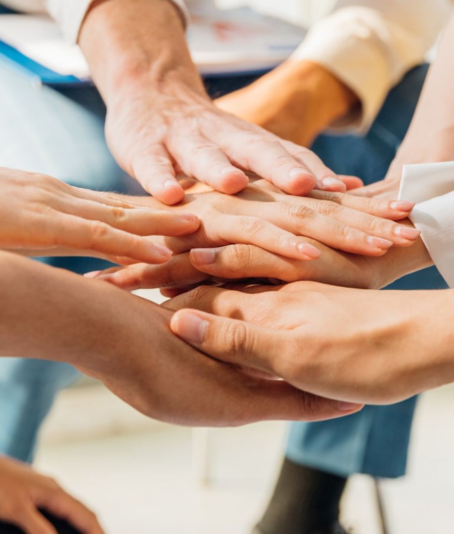 The Claiborne employee team putting hands together stacked on top of each other for team support