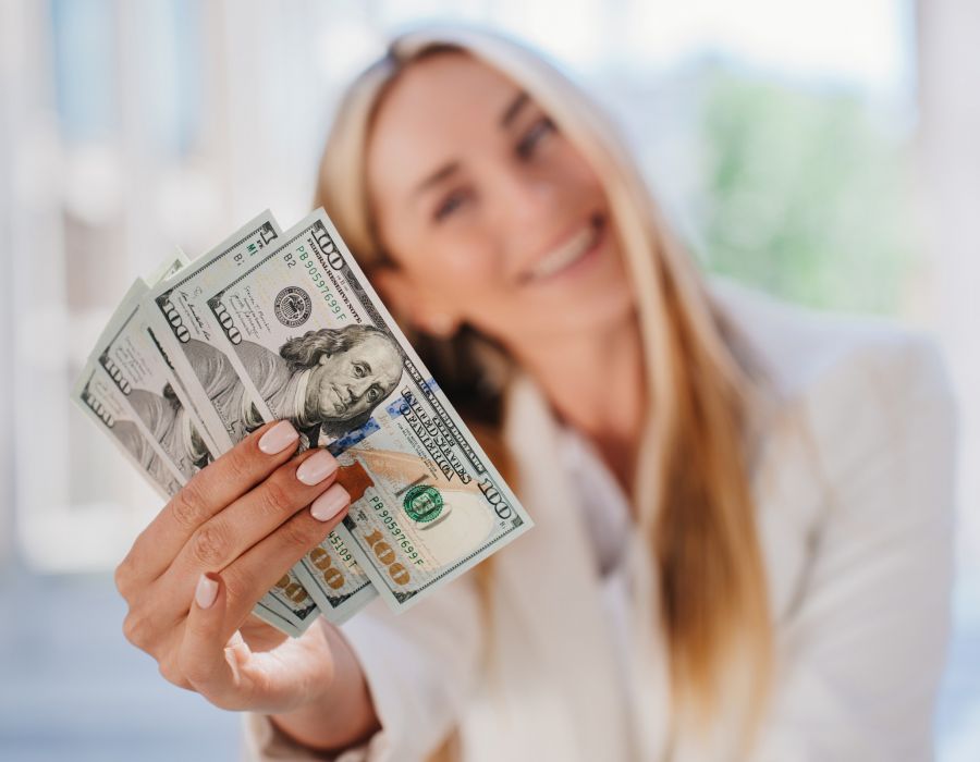 The Claiborne cheerful businesswoman holding one-hundred dollar bills