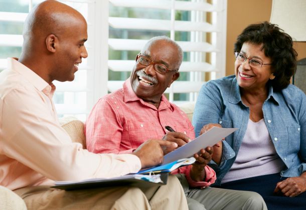 A financial advisor meets with an older couple to review documents.