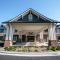 Front view of Brickmont at Woodstock's entrance with a covered driveway, stone accents, and landscaped greenery.