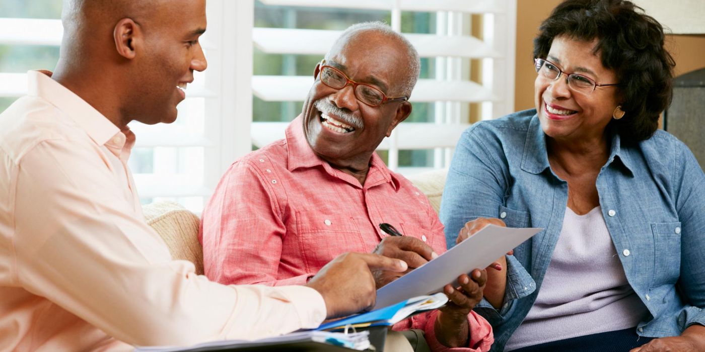 A financial advisor meets with an older couple to review documents.