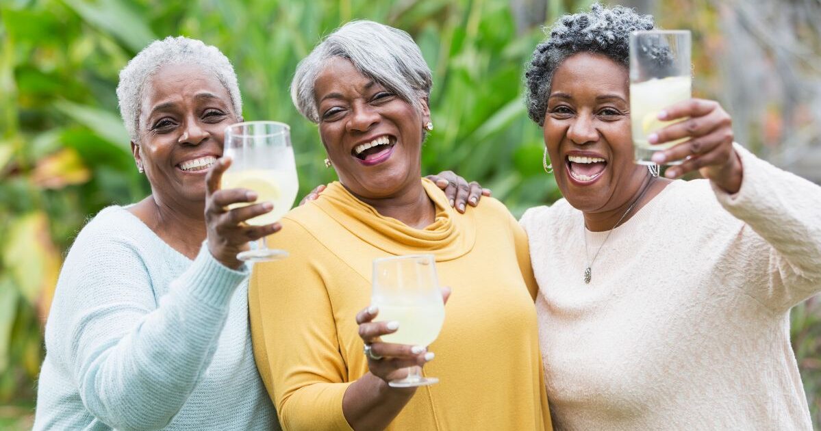 Senior women happily celebrating with drinks