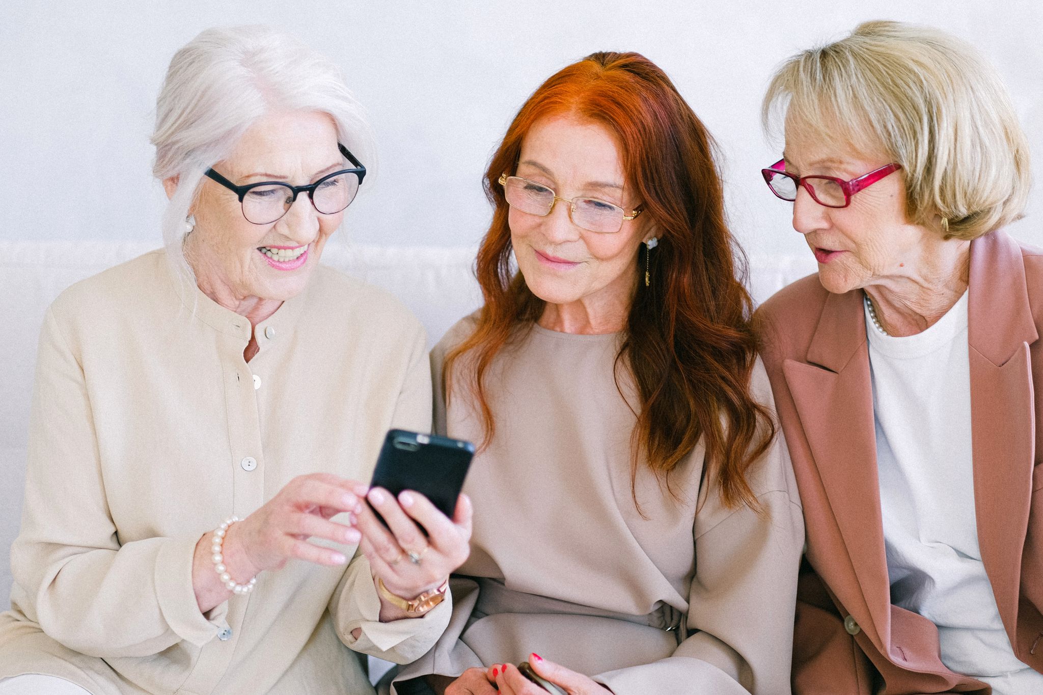Senior women looking at a smartphone together.