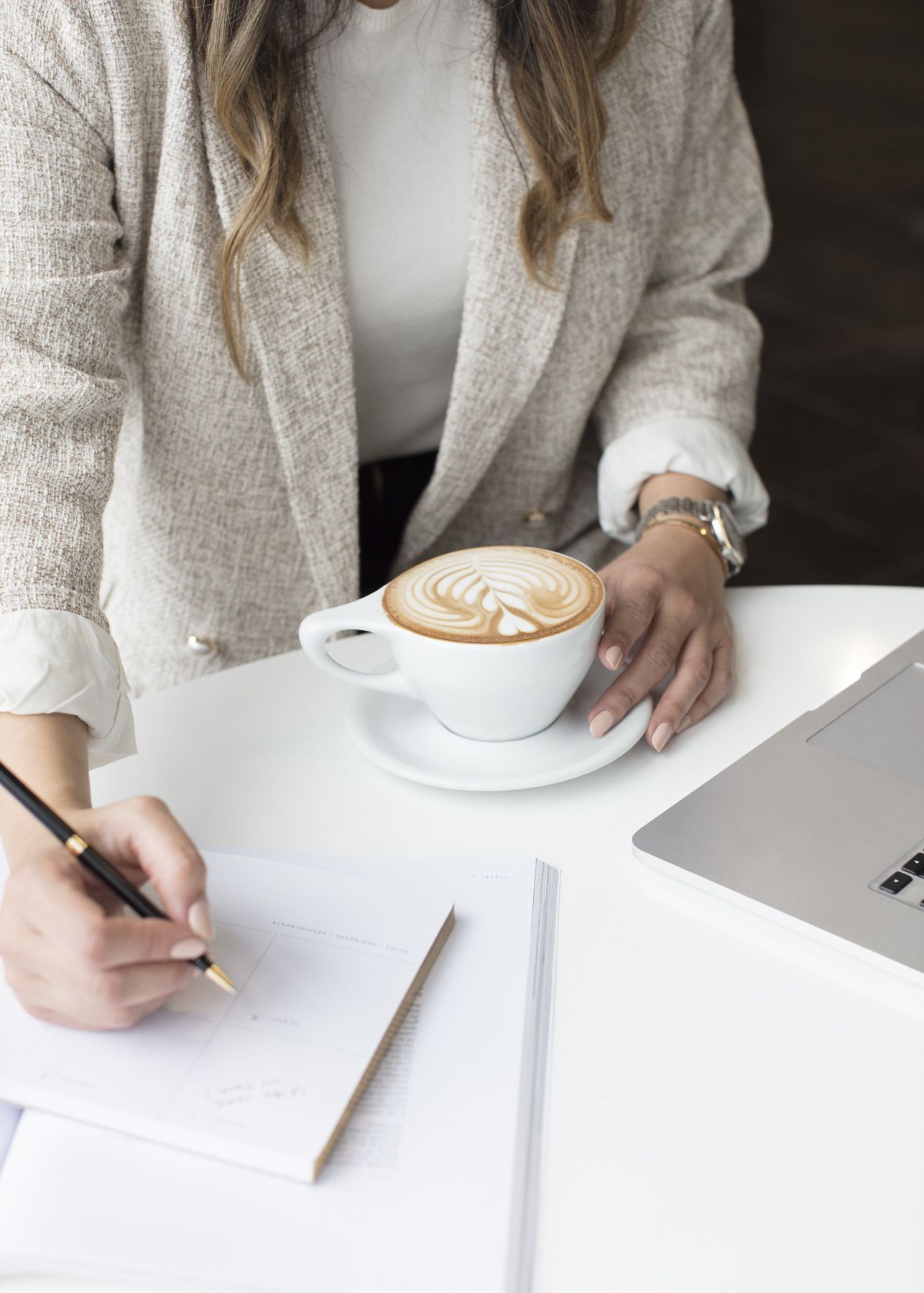 woman with a latte writing down a plan