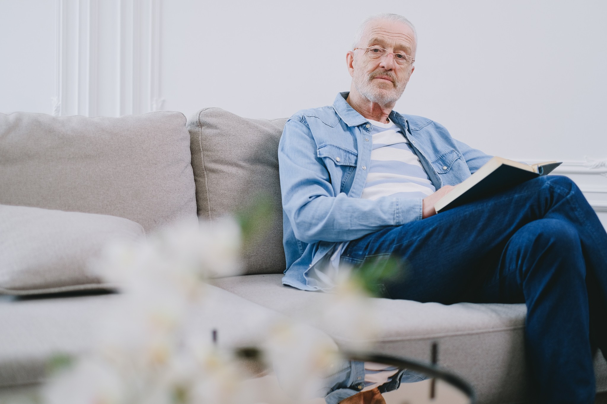 Man sitting on a couch with a book